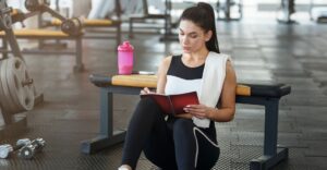 woman writing gym schedule in journal